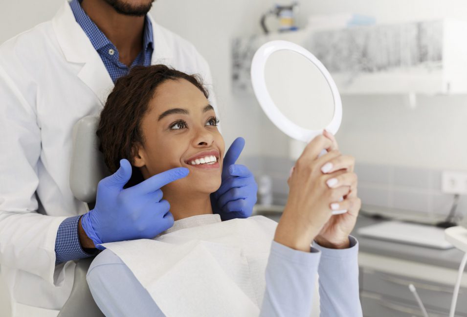 Patient checking dental implant in Kitchener